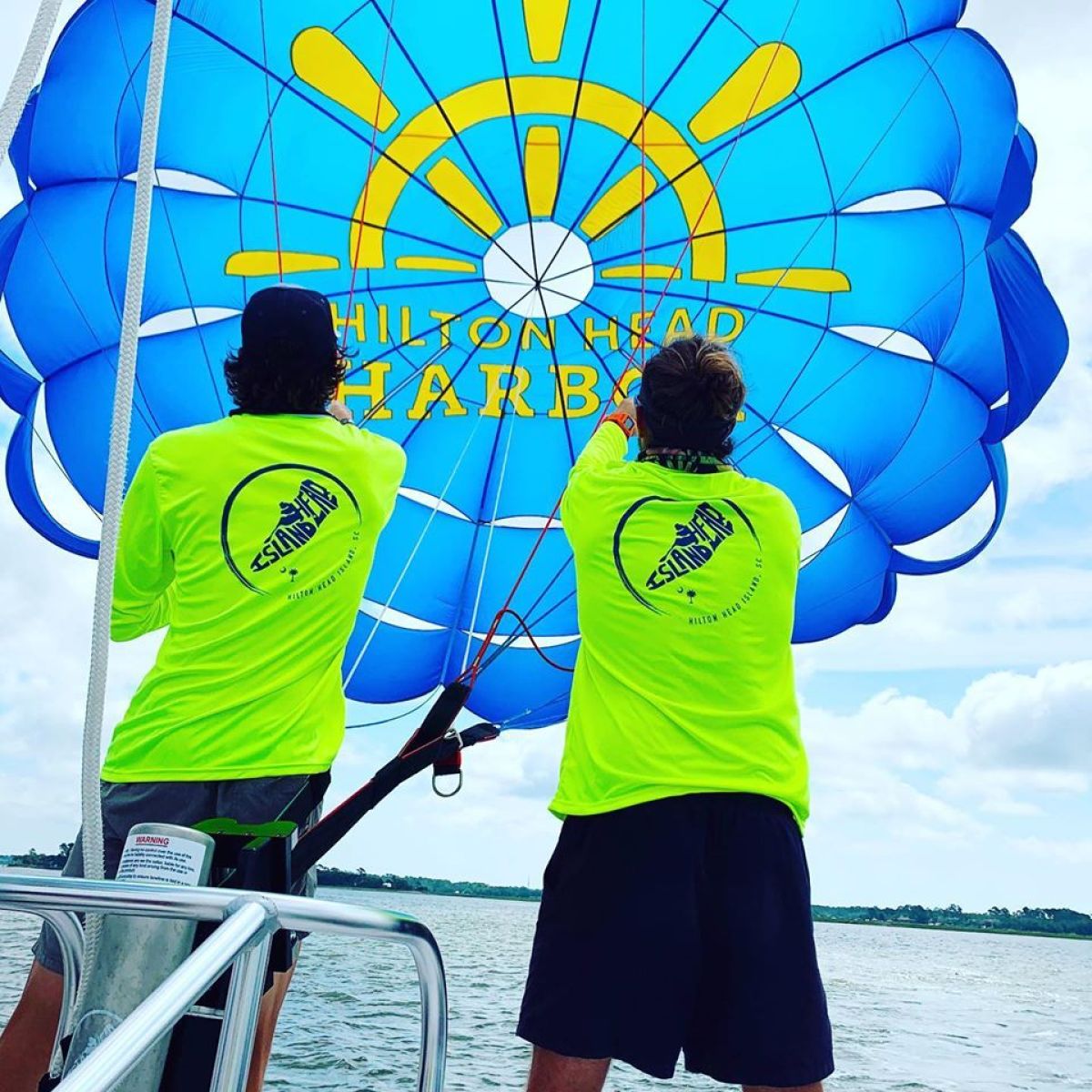 a group of people standing next to a body of water